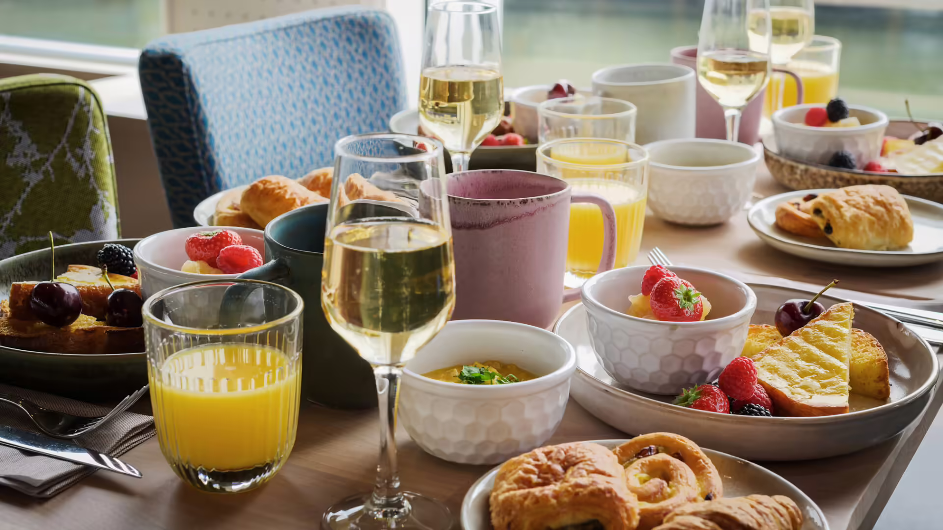 Table garnie pour un brunch raffiné à bord d'un bateau de croisière sur la Seine à Paris, avec viennoiseries, fruits et boissons | Le Capitaine Fracasse