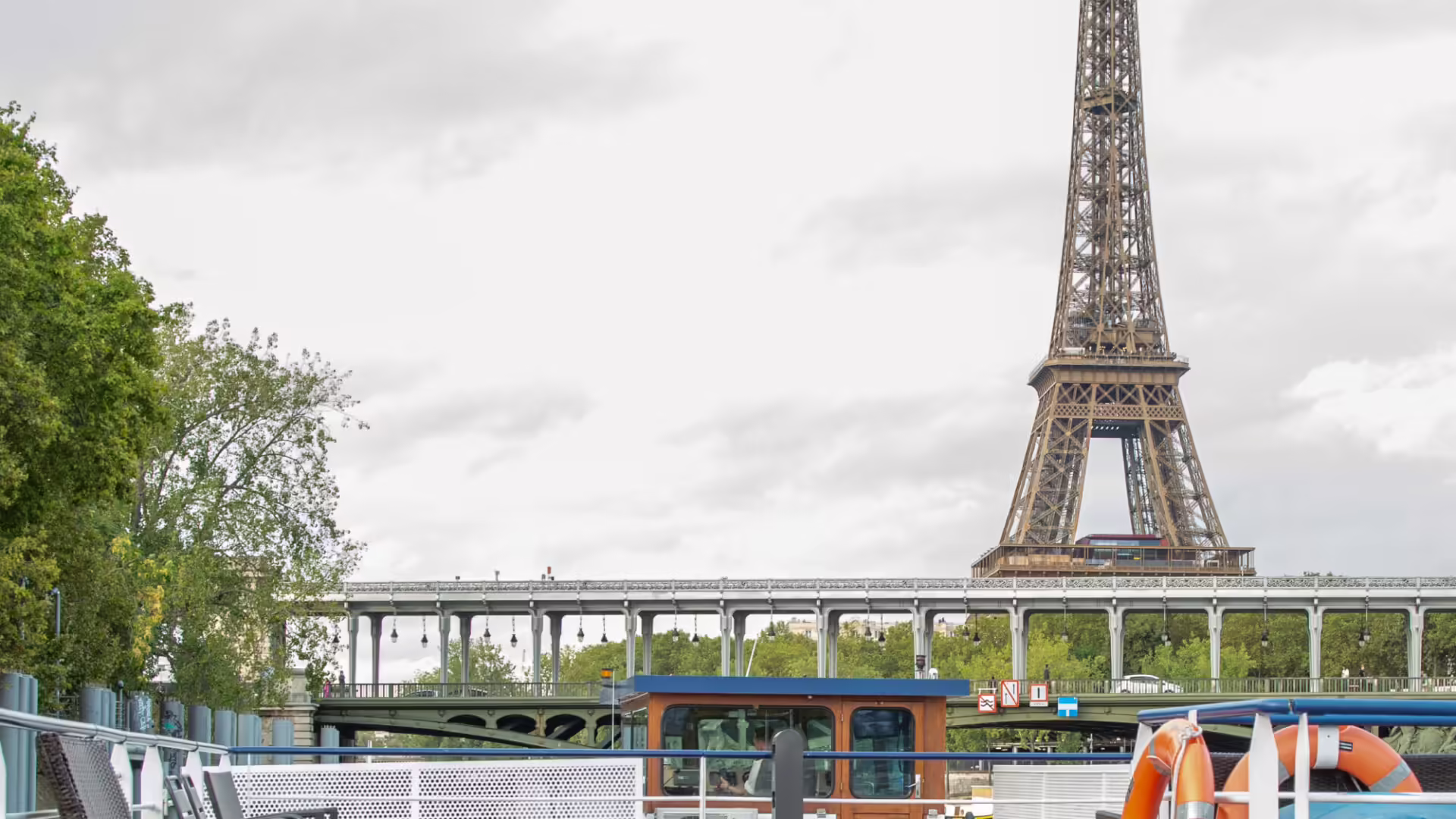 Vue depuis un bateau de croisière sur la Seine avec la Tour Eiffel et un pont parisien | Le Capitaine Fracasse